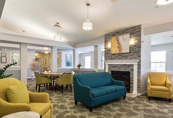 A modern living room with a cozy fireplace, vibrant furniture, and elegant lighting.