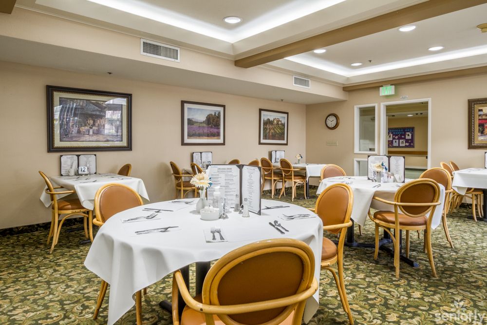 A well-lit restaurant dining room with neatly arranged tables and chairs.