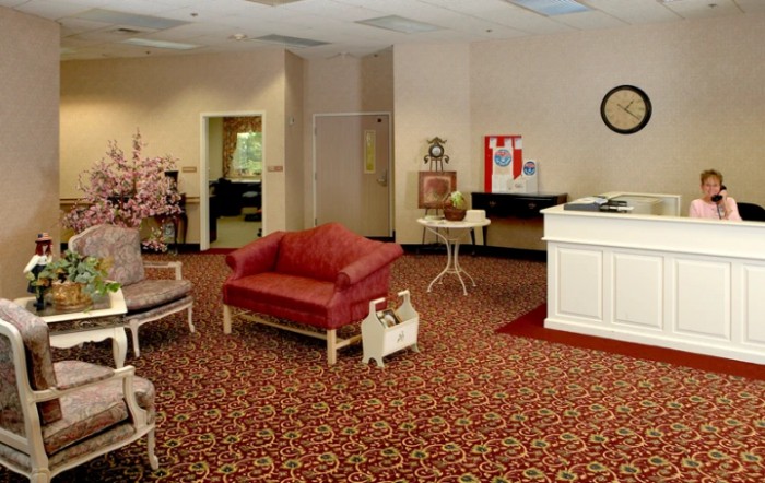 A cozy lobby area with vintage-style furniture and a patterned carpet.