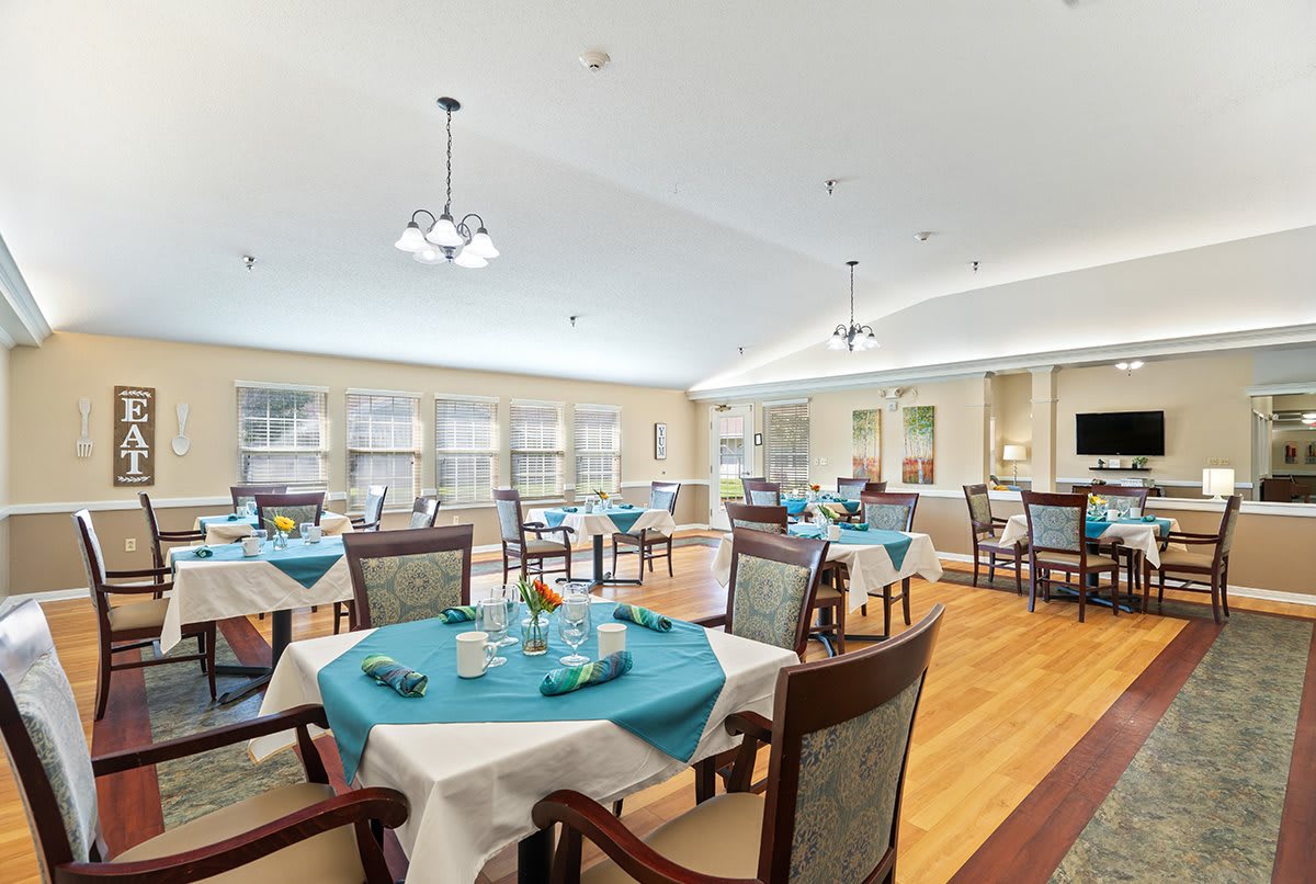 Spacious dining area with neatly set tables and elegant lighting.