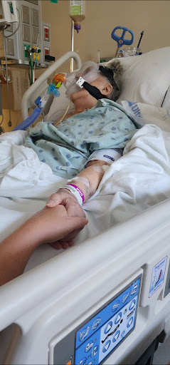 A moment of connection and support between loved ones in a hospital setting.