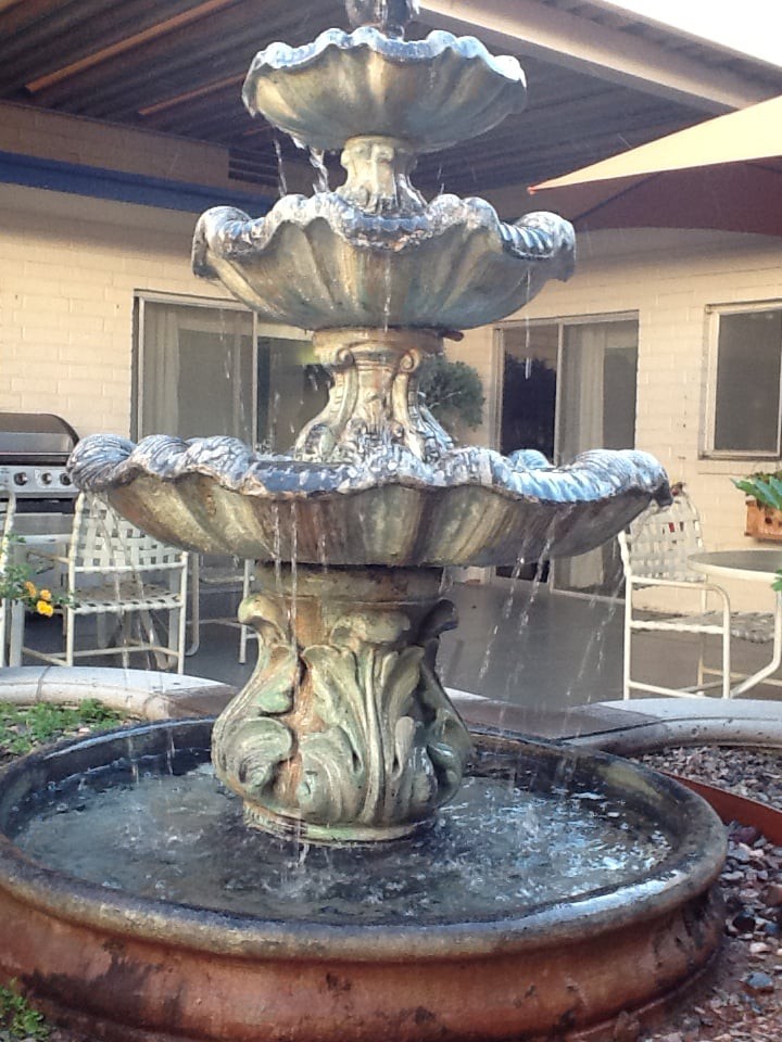 A multi-tiered garden fountain in a courtyard setting.