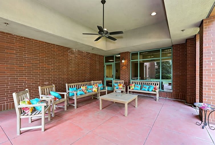 A cozy outdoor patio with comfortable seating and vibrant decorative pillows.