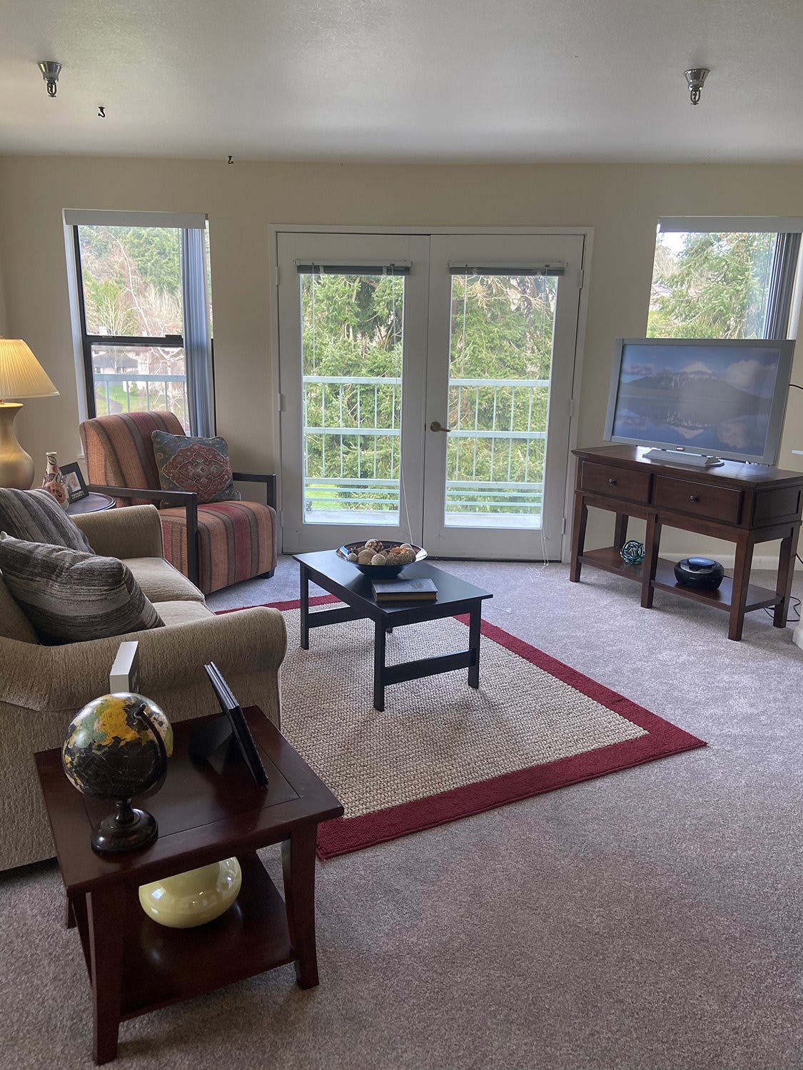 A cozy living room with comfortable seating, a television, and natural light.