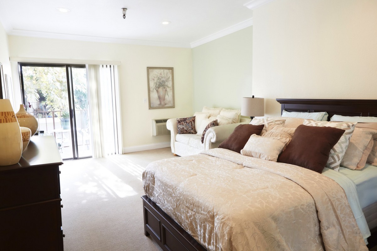 A bright and cozy bedroom with a large bed and sofa.
