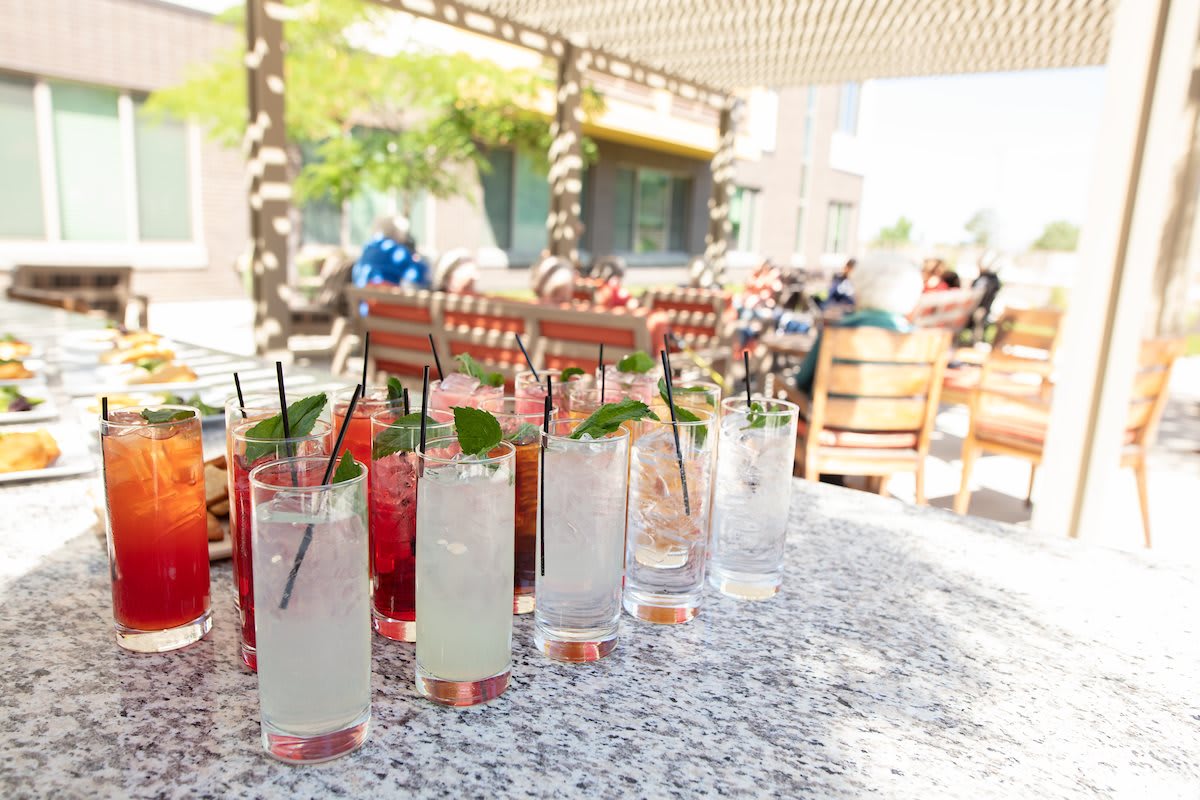 A variety of refreshing cocktails on an outdoor table in a sunny setting.