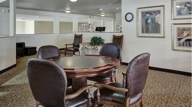 A modern meeting room with a round table and leather chairs.
