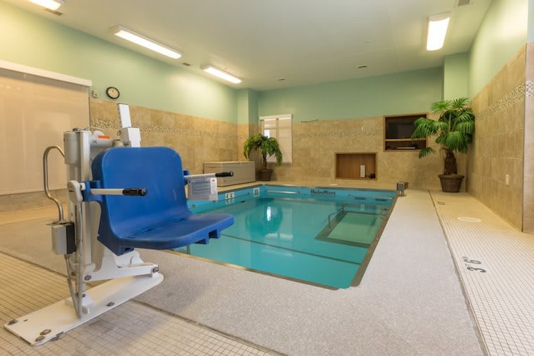 An indoor therapy pool with an accessibility chair for easy entry.
