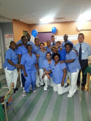 A cheerful group of healthcare professionals posing together in a hospital setting.