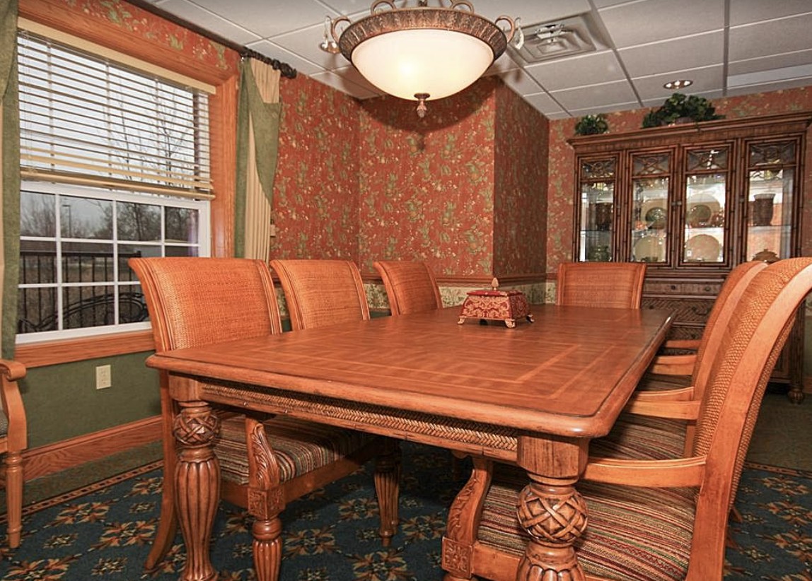 A cozy dining room featuring a large wooden table and elegant decor.