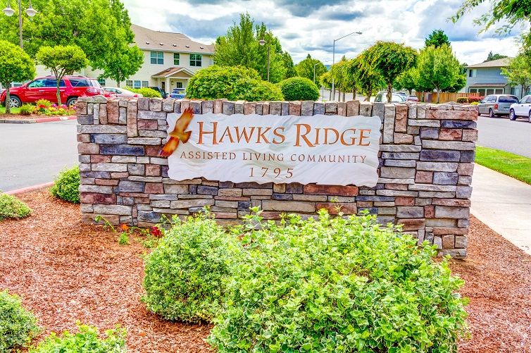 Entrance sign for Hawks Ridge residential community surrounded by well-maintained landscaping.