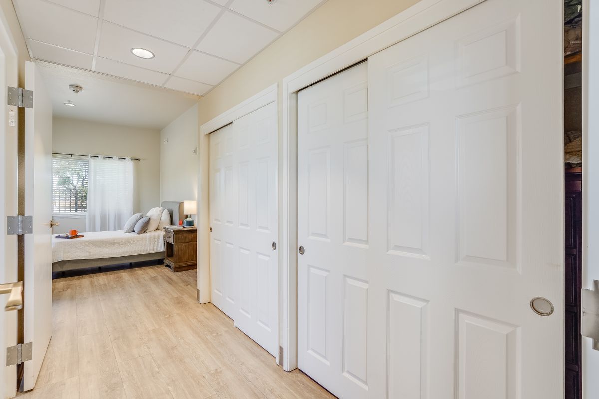 A modern bedroom with hardwood floors and double closets.