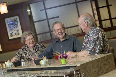 A group of seniors enjoying a conversation at a table indoors.