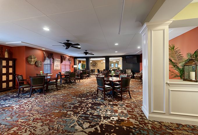 Spacious dining area with tables and chairs arranged on a patterned carpet.