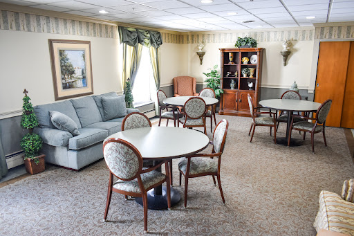 A cozy lounge area featuring round tables, chairs, and a comfortable sofa.