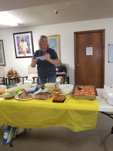 A community event featuring a spread of delicious homemade dishes, with a volunteer ready to serve.