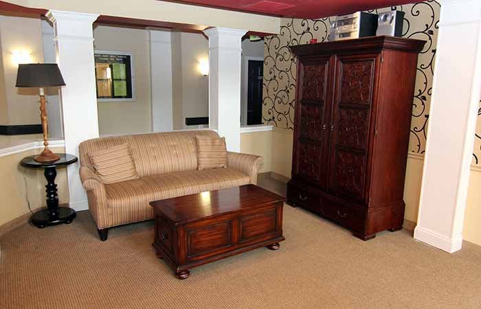 A cozy living room with a sofa, coffee table, and wardrobe.