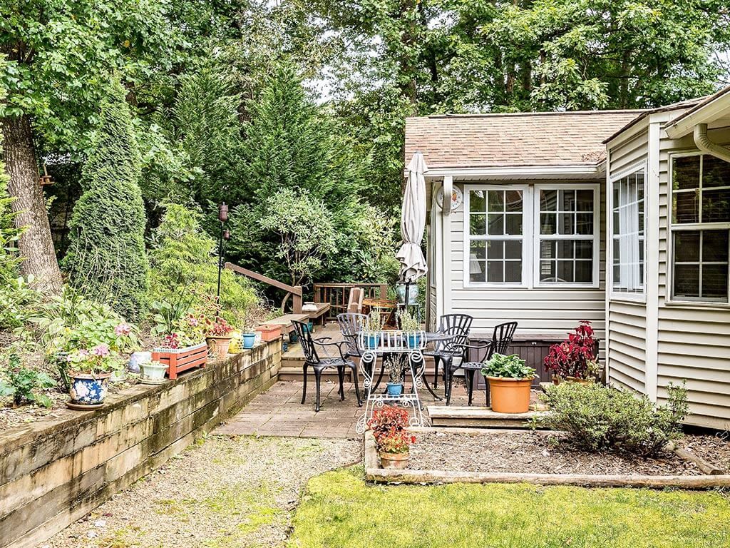 A cozy garden patio with outdoor seating and lush greenery.
