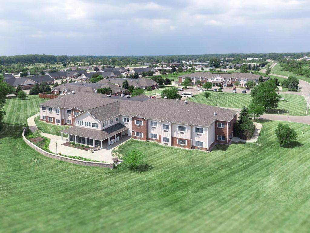 Aerial view of a suburban residential building surrounded by grassy areas.