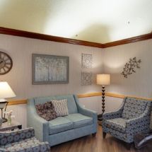 A cozy living room with a sofa, two armchairs, and decorative elements.