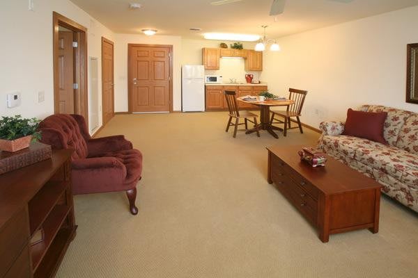 A spacious living room area with a dining table and chairs near the kitchen.