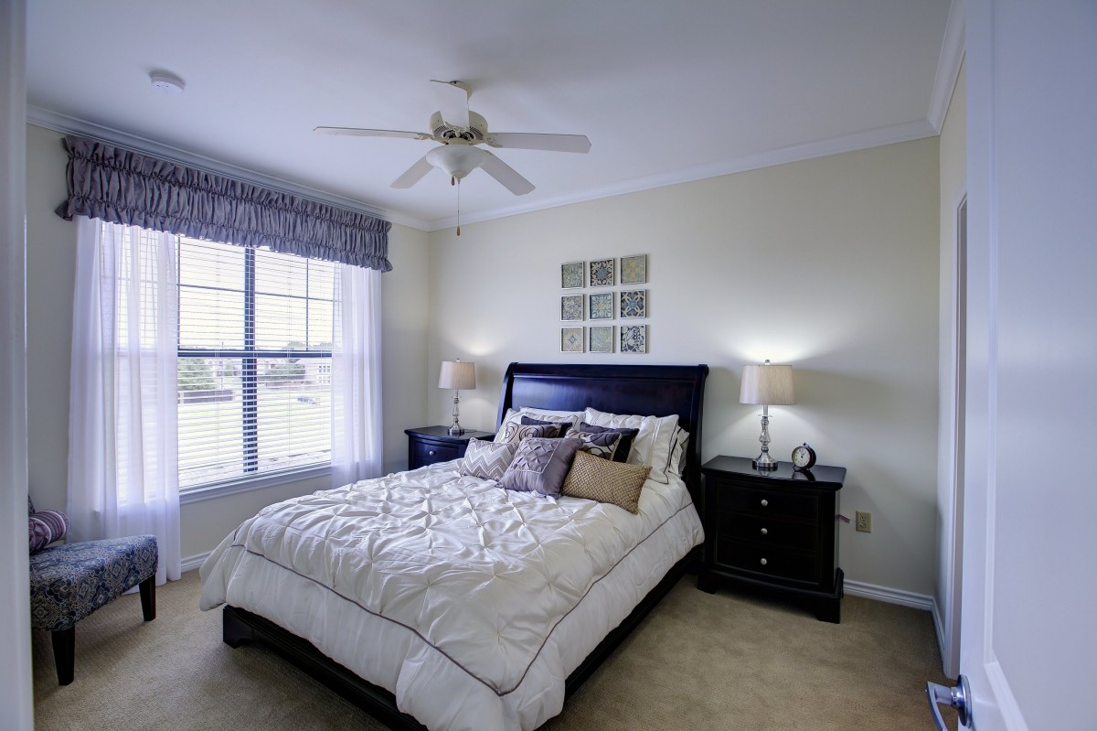 A cozy bedroom with a neatly made bed and elegant decor.