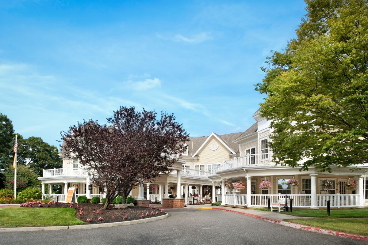 A scenic view of a large building with an inviting entrance surrounded by trees.