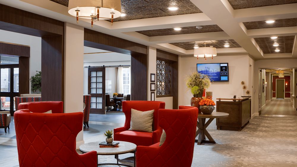 A modern lobby with red seating, stylish lighting, and decorative elements.
