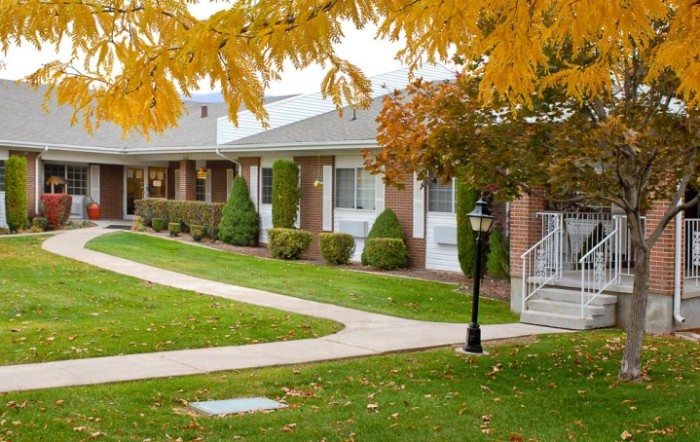 A scenic view of a residential area in autumn with colorful leaves and well-maintained pathways.