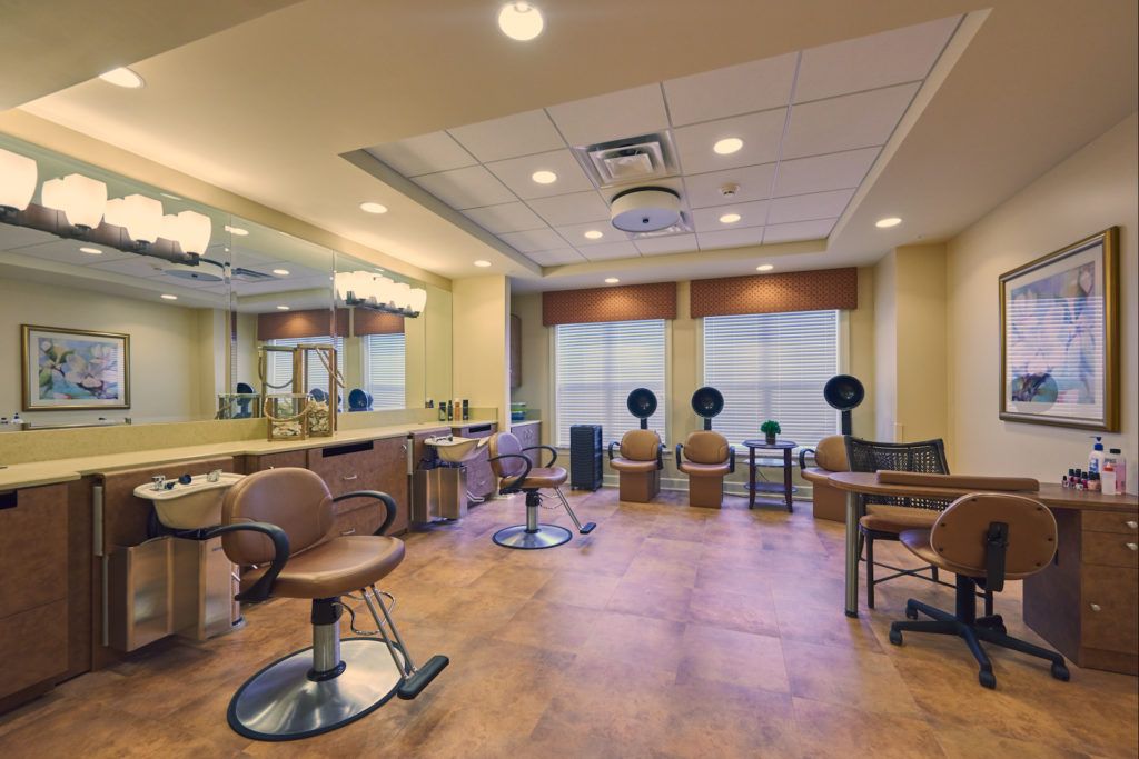A modern salon interior featuring styling chairs, mirrors, and hair dryers.