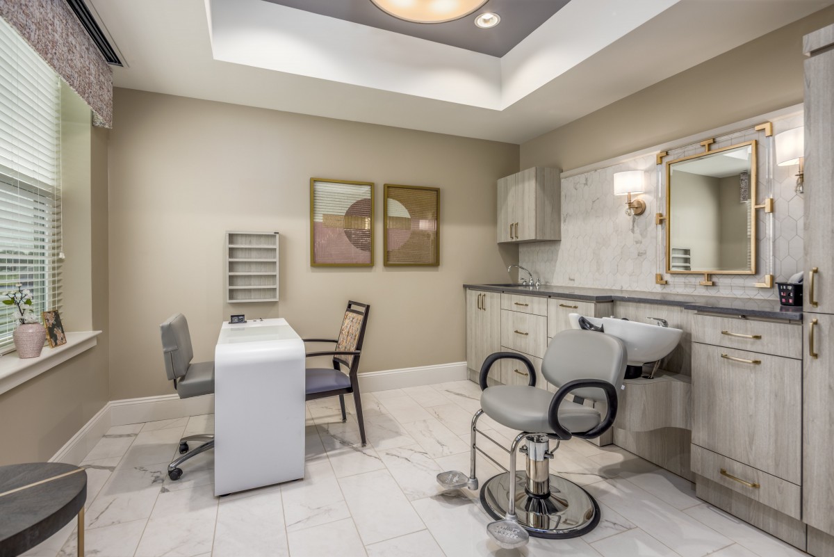 A modern beauty salon interior with comfortable seating and workstations.