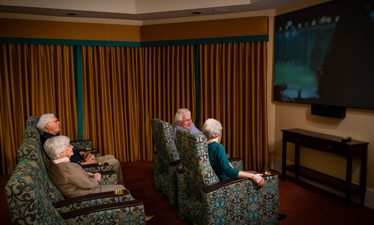A group of seniors enjoying a movie in a cozy living room setting.