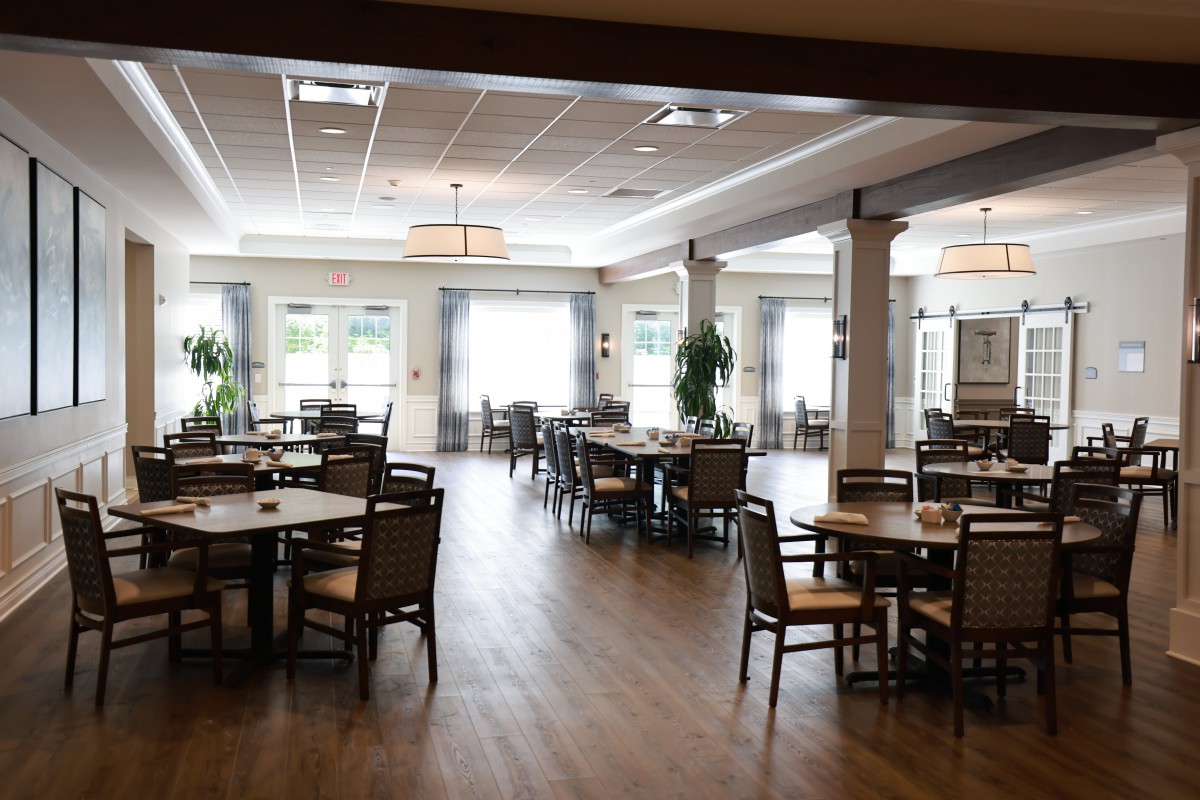 An elegant dining room interior with neatly arranged tables and chairs.