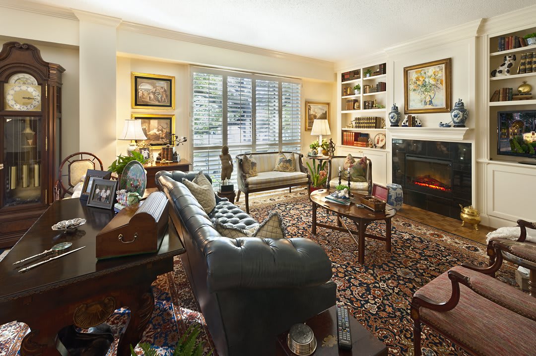 A cozy living room with elegant furniture, a rug, and a fireplace.