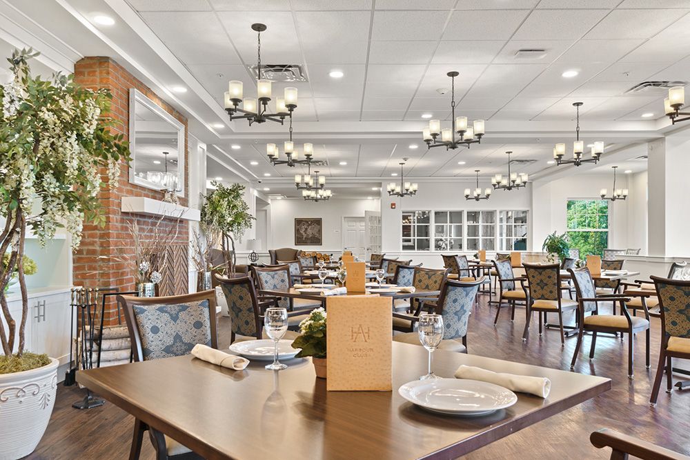 A spacious and elegantly designed dining room with neatly arranged tables and chandeliers.