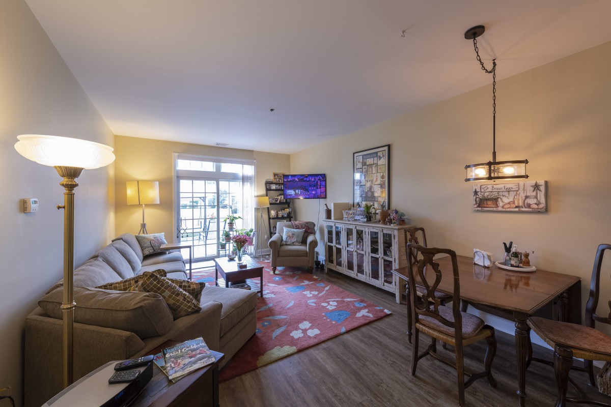 A cozy living room with a sofa, dining area, and various decorative elements.