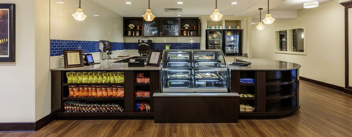 A modern cafe interior featuring a bakery display with snacks and beverages.