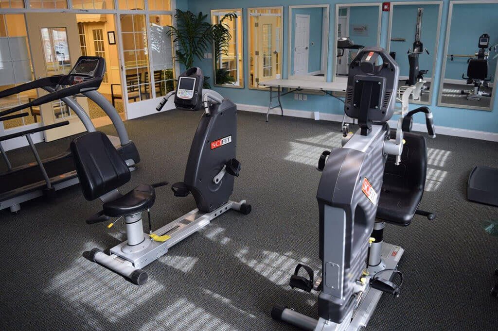 A gym setting featuring stationary bikes and various exercise equipment.