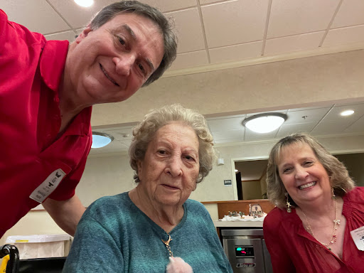 A cheerful moment captured with a senior citizen and two caregivers.