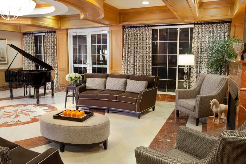 A modern living room featuring a grand piano, cozy seating area, and elegant lighting.