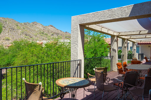 A cozy balcony with comfortable seating and a stunning view of the mountains, perfect for enjoying sunny days.
