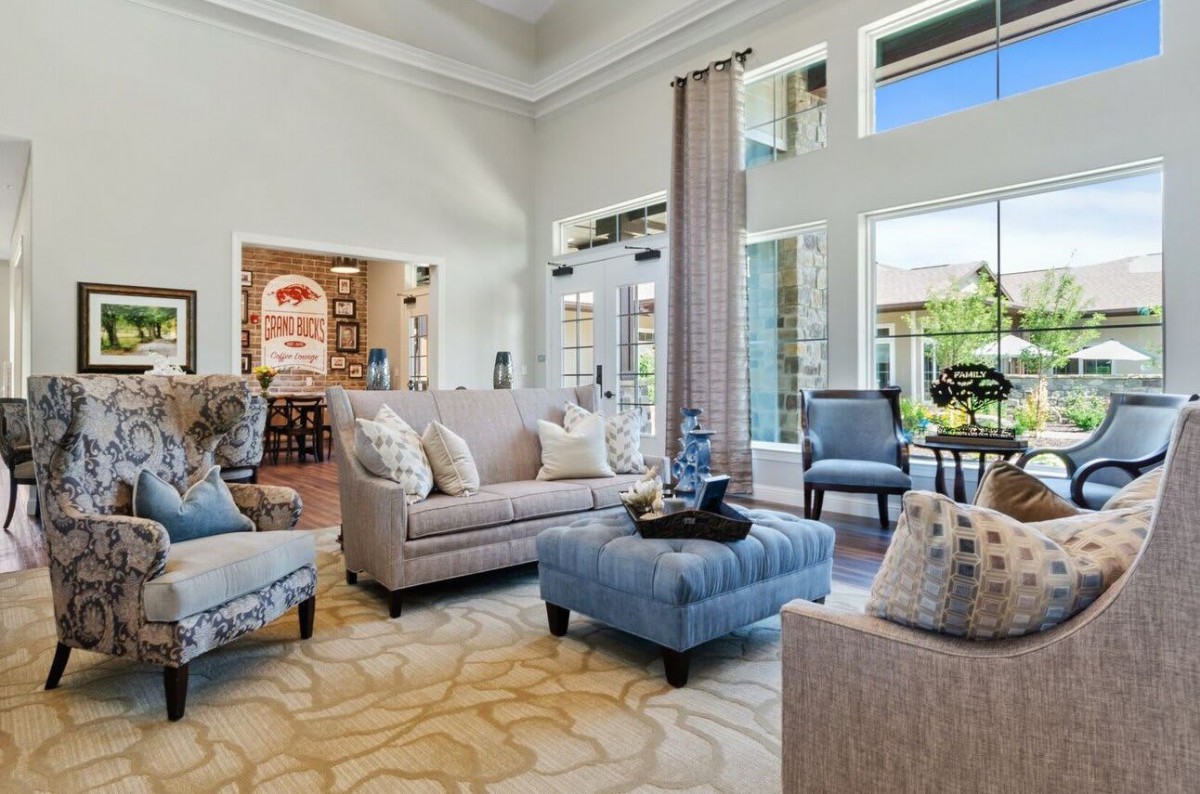 A spacious and well-lit living room with modern furniture and large windows.