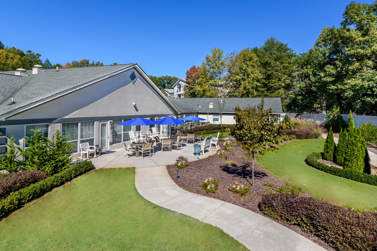 A beautiful outdoor patio area surrounded by a well-maintained garden.