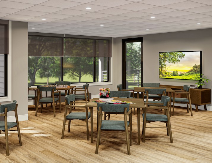 A modern dining area with wooden tables and chairs, surrounded by large windows.
