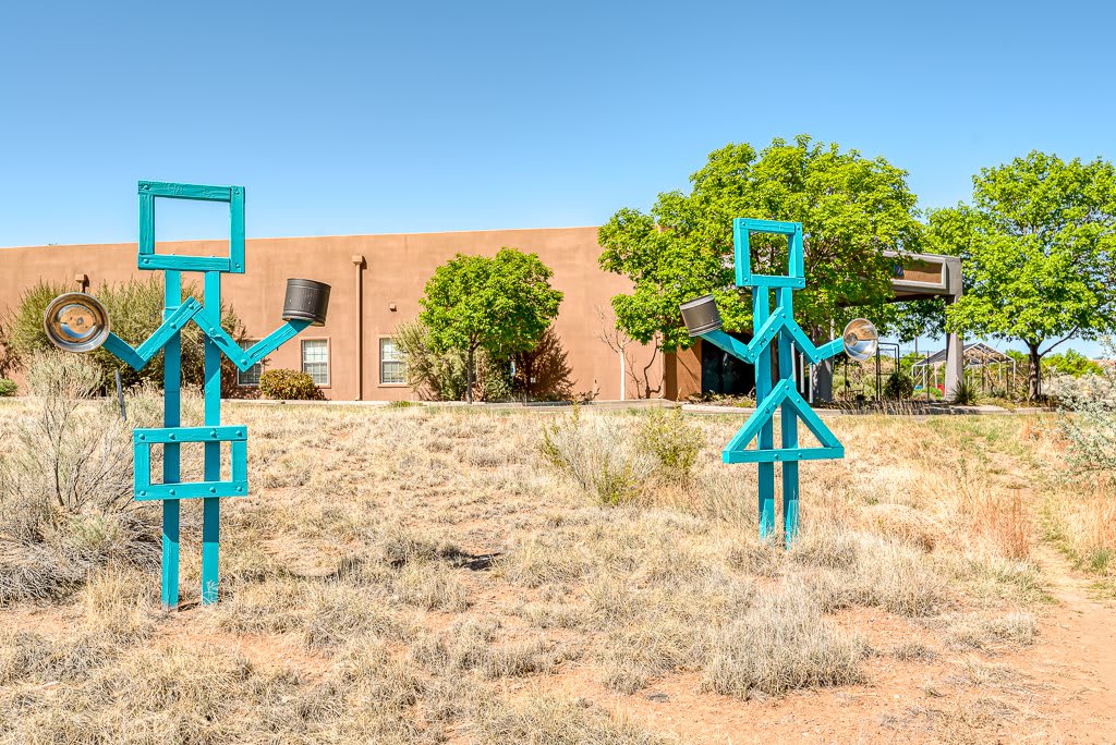 Outdoor metal sculptures with geometric shapes in a grassy landscape.