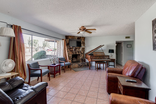 A cozy living room featuring a grand piano, comfortable seating, and a warm ambiance.