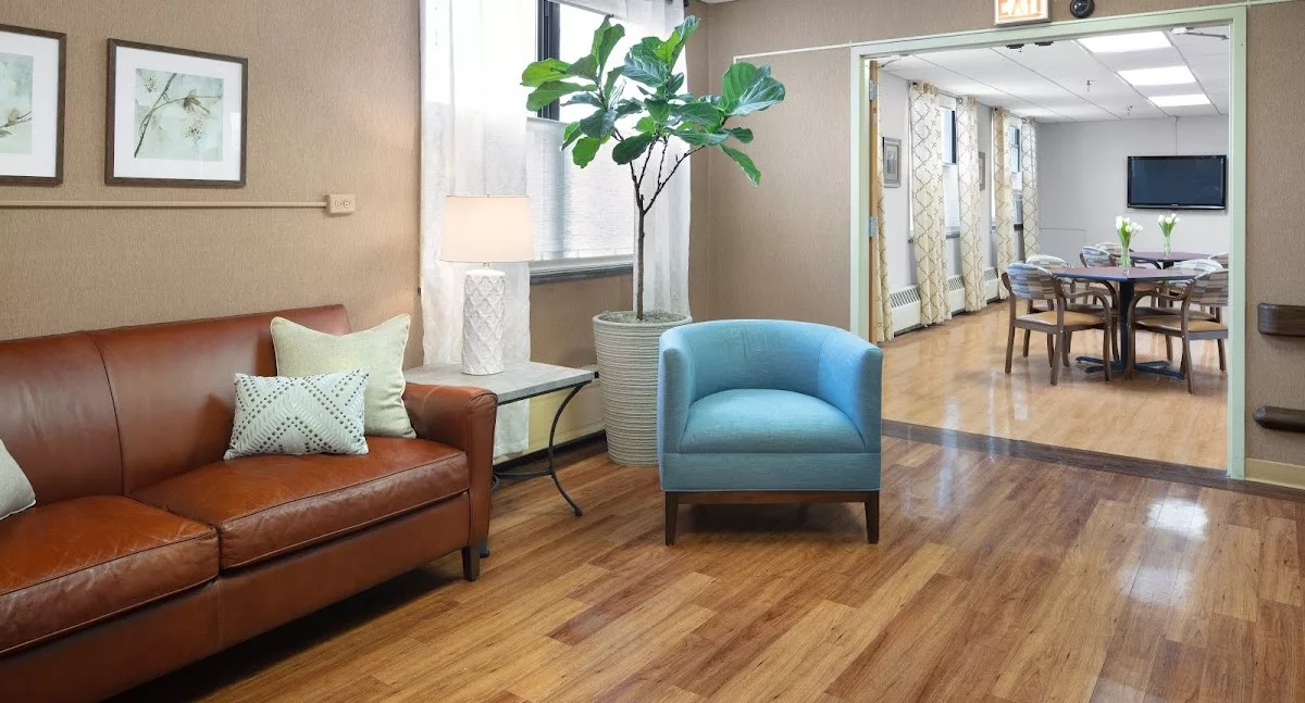 A cozy waiting room with comfortable seating and a potted plant.