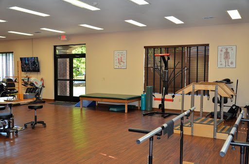 A well-lit physical therapy room equipped with exercise tools and a comfortable waiting area.