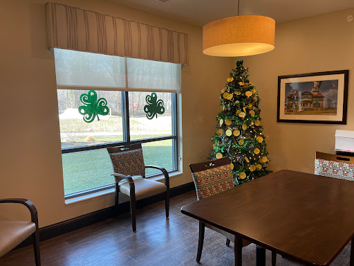 A cozy dining area featuring a decorated Christmas tree and festive window adornments.