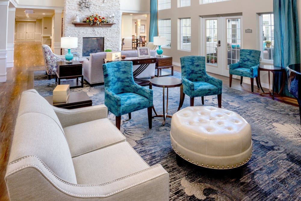 A modern living room with blue chairs and a white sofa, featuring stylish interior design.
